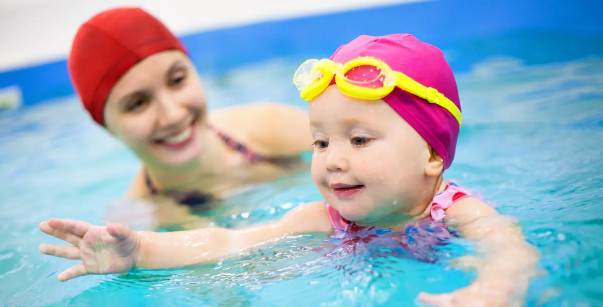 بالصور .. هكذا تهتم البطلة الأولمبية ميلاني رايت بتعليم طفلتها السباحة