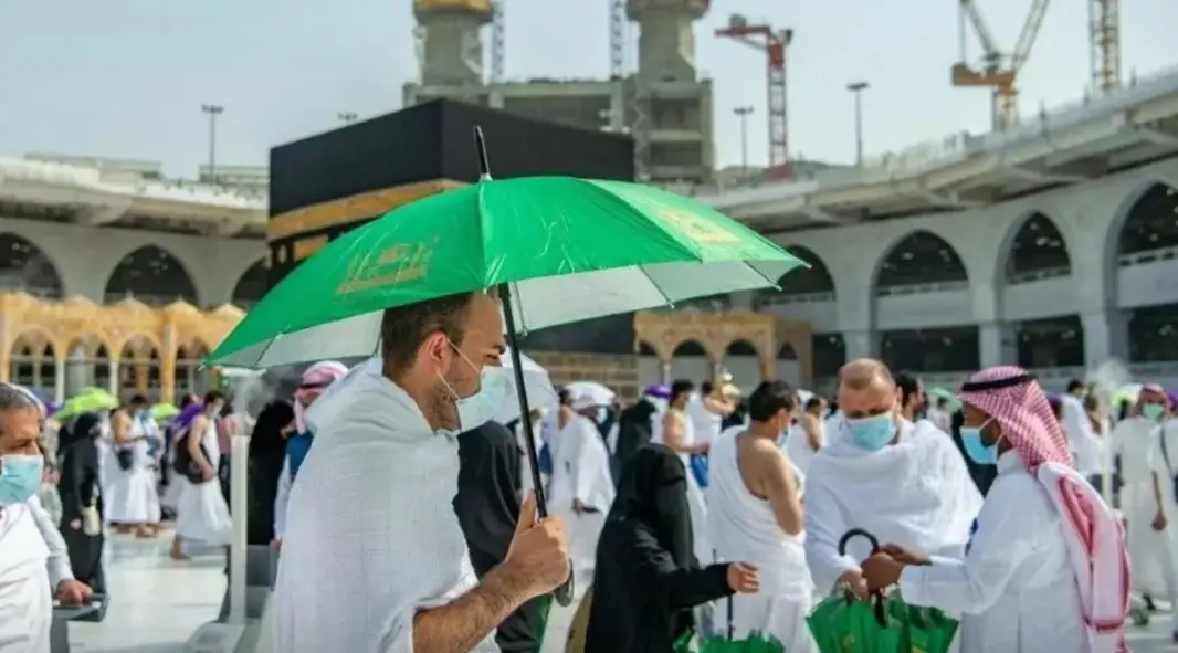 رجل يمسك بمظلة في الحج
